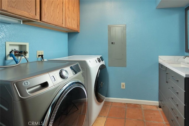 clothes washing area featuring sink, washer and clothes dryer, tile patterned flooring, electric panel, and cabinets