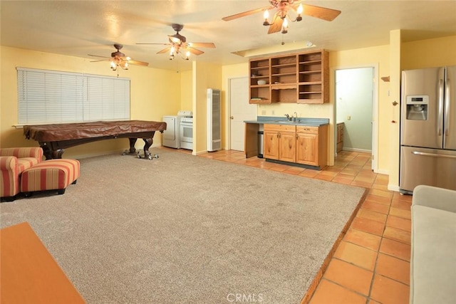 playroom with separate washer and dryer, sink, and light tile patterned floors