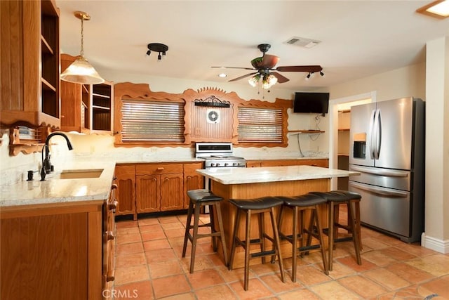 kitchen with sink, a breakfast bar, stainless steel refrigerator with ice dispenser, a kitchen island, and decorative light fixtures