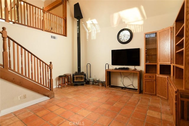 living room featuring light tile patterned flooring and a wood stove