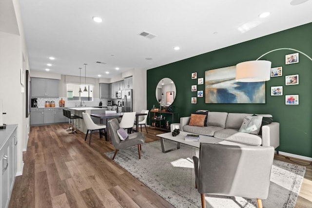 living room with light wood-type flooring and sink