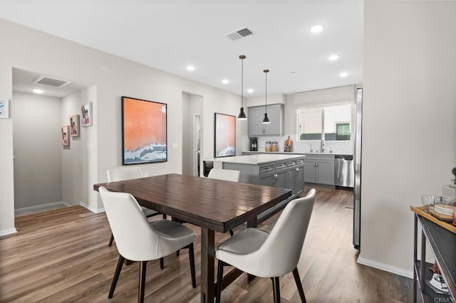 dining space with sink and hardwood / wood-style floors