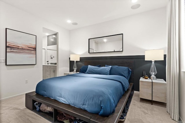 bedroom featuring light carpet and ensuite bath