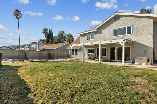 back of house with a patio and a yard