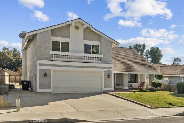 front of property with a balcony, a garage, and a front lawn