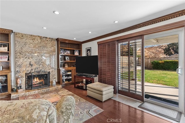 living room featuring ornamental molding, built in features, a wealth of natural light, and a high end fireplace