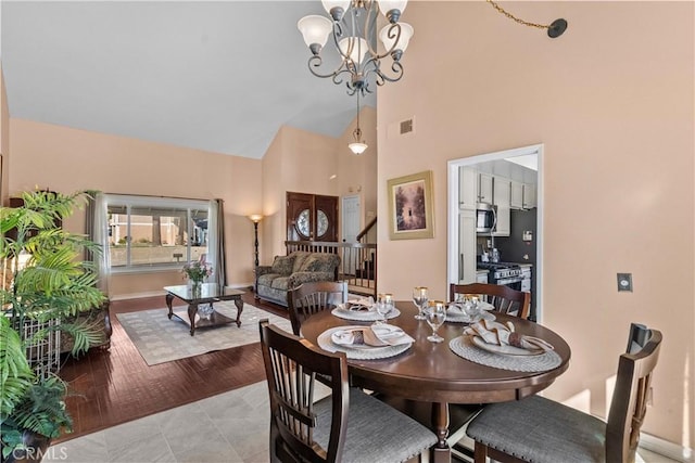 dining space with high vaulted ceiling and a chandelier