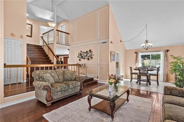 living room featuring hardwood / wood-style flooring, a chandelier, and high vaulted ceiling