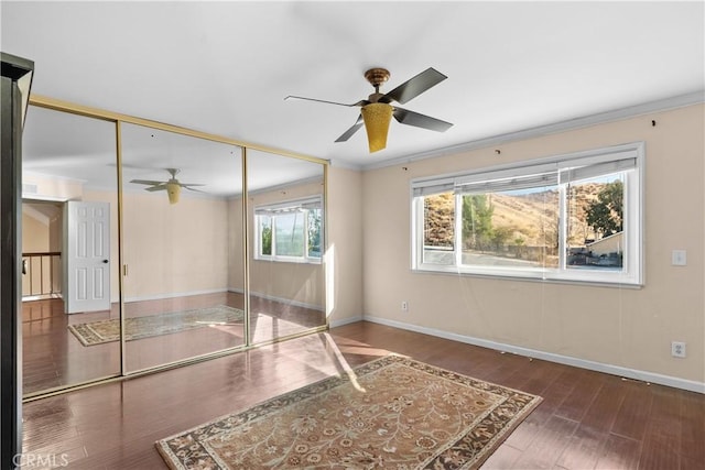 spare room with ceiling fan, crown molding, and dark wood-type flooring