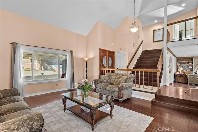 living room with hardwood / wood-style flooring and high vaulted ceiling