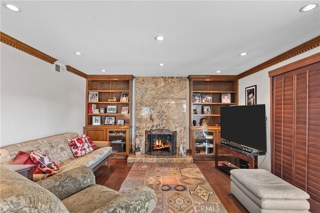 living room with dark wood-type flooring, built in shelves, a high end fireplace, and crown molding