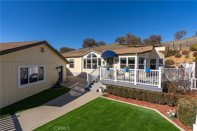 view of front of home with a wooden deck and a front yard