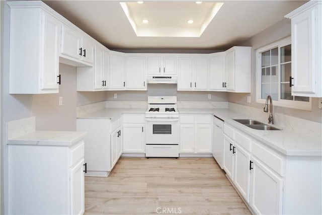 kitchen with sink, white appliances, white cabinets, and a raised ceiling