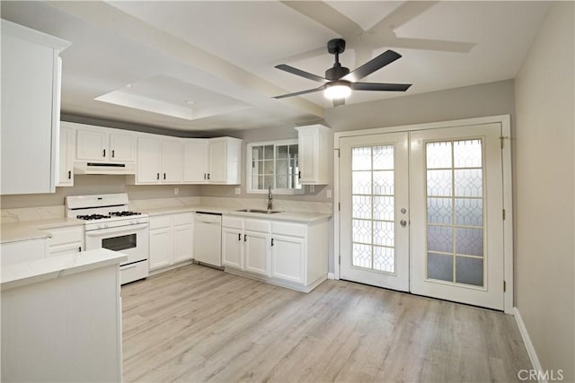 kitchen featuring white appliances, white cabinets, sink, french doors, and a raised ceiling