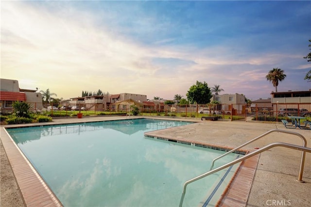 pool at dusk with a patio area