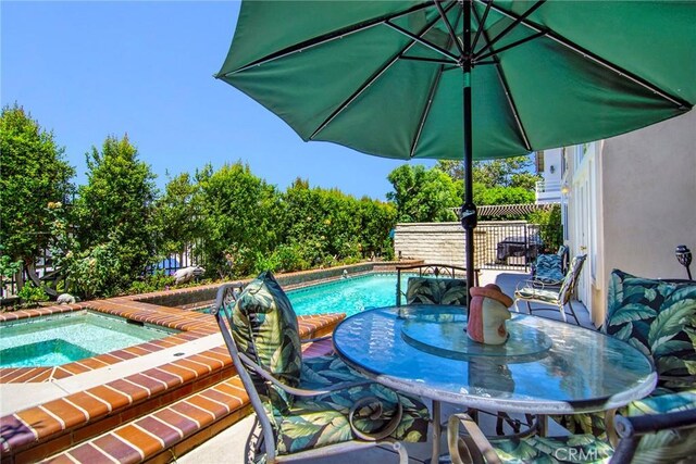 view of pool with a hot tub