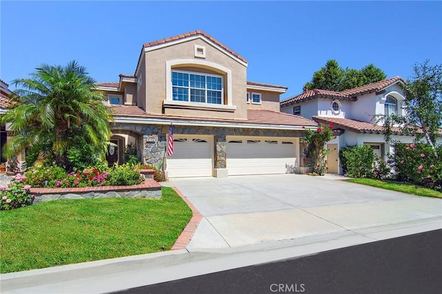 mediterranean / spanish-style home with a front yard and a garage