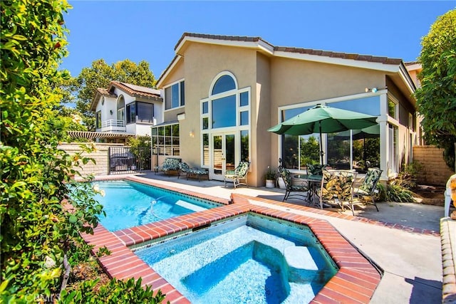 back of house featuring a patio and a swimming pool with hot tub