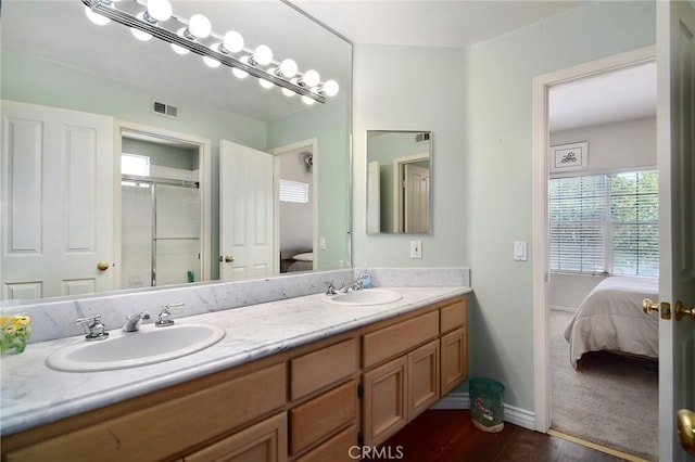 bathroom featuring hardwood / wood-style flooring, an enclosed shower, and vanity