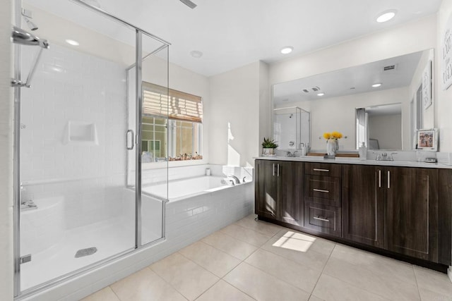 bathroom with plus walk in shower, vanity, and tile patterned flooring