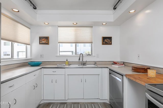 kitchen with sink, white cabinets, stainless steel dishwasher, and plenty of natural light