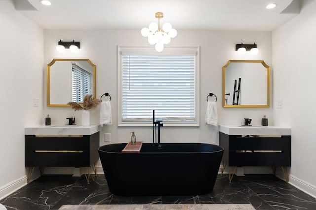 bathroom with vanity, a chandelier, and a tub