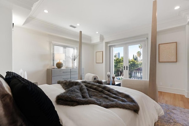 bedroom featuring french doors, a tray ceiling, hardwood / wood-style floors, and access to outside