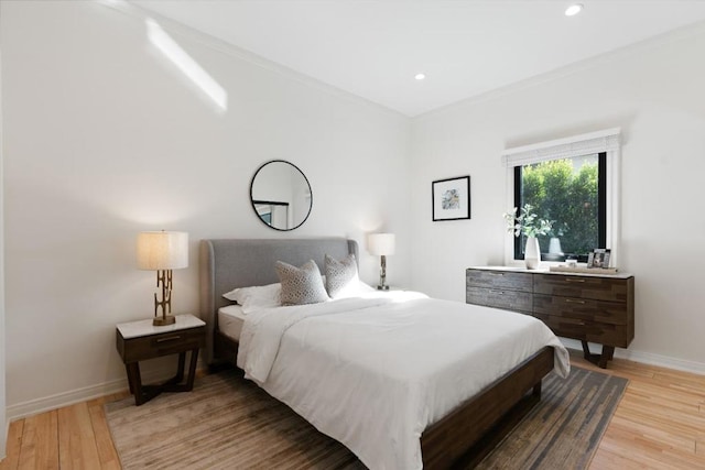 bedroom featuring ornamental molding and light hardwood / wood-style flooring