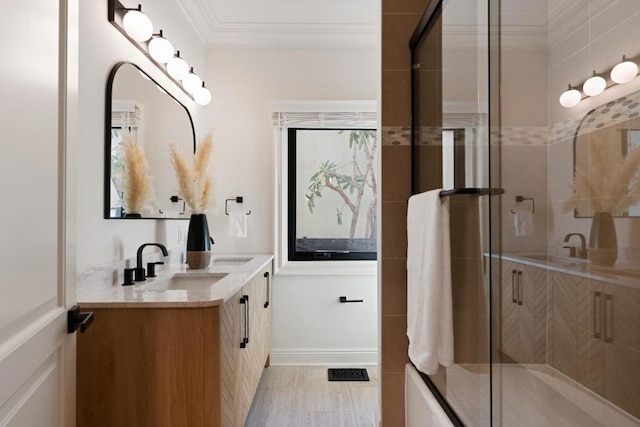 bathroom with crown molding, vanity, and a shower with shower door