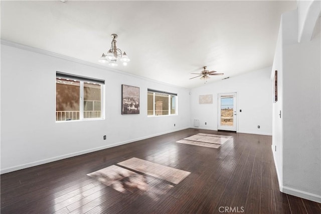 unfurnished living room featuring ornamental molding, ceiling fan with notable chandelier, vaulted ceiling, and dark hardwood / wood-style flooring