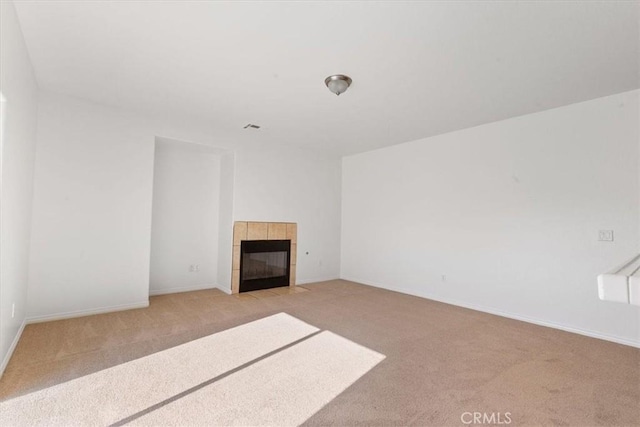 carpeted spare room featuring a fireplace