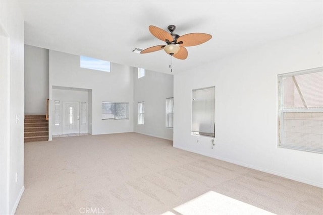 unfurnished living room featuring light carpet and ceiling fan