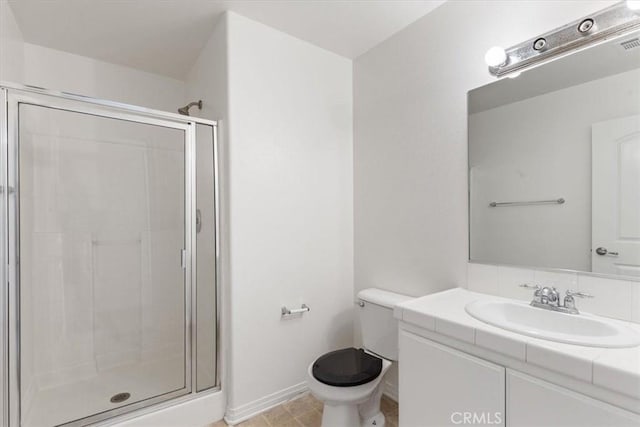 bathroom featuring a shower with door, toilet, and vanity