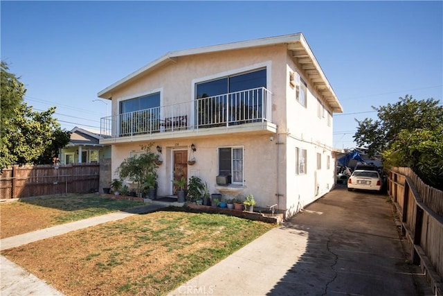 view of front facade with a balcony and a front yard