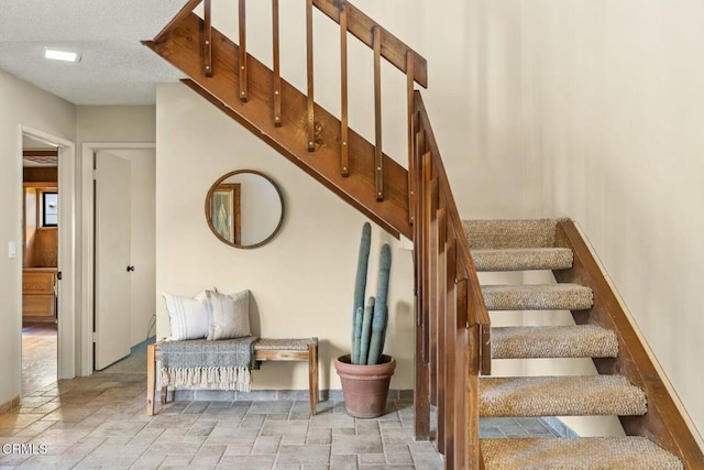 stairway with a textured ceiling