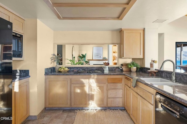 kitchen featuring light brown cabinetry, sink, black appliances, and dark stone countertops