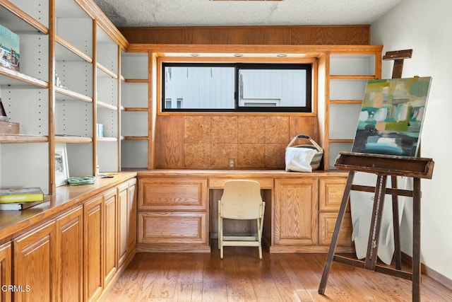 office with wood-type flooring and built in desk