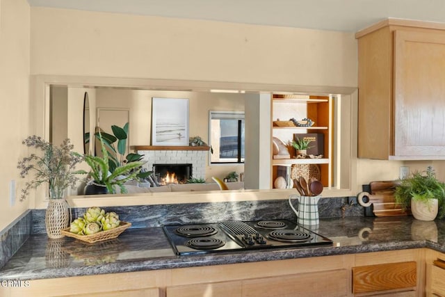 kitchen with black electric cooktop, light brown cabinets, and a fireplace