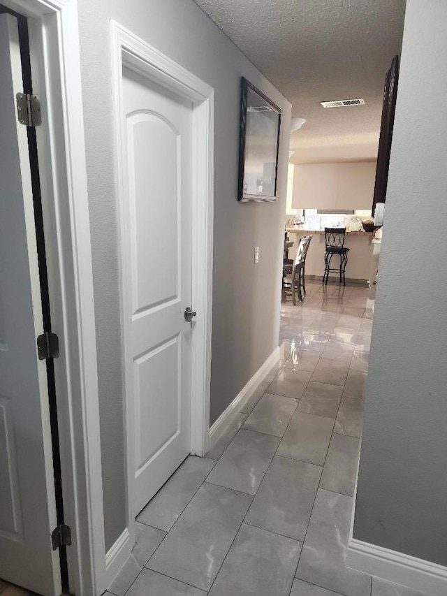 hall with a textured ceiling