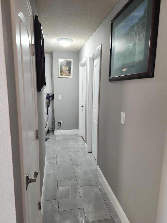 hall featuring a textured ceiling