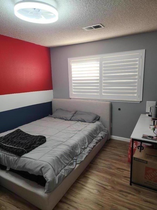 bedroom featuring dark wood-type flooring and a textured ceiling