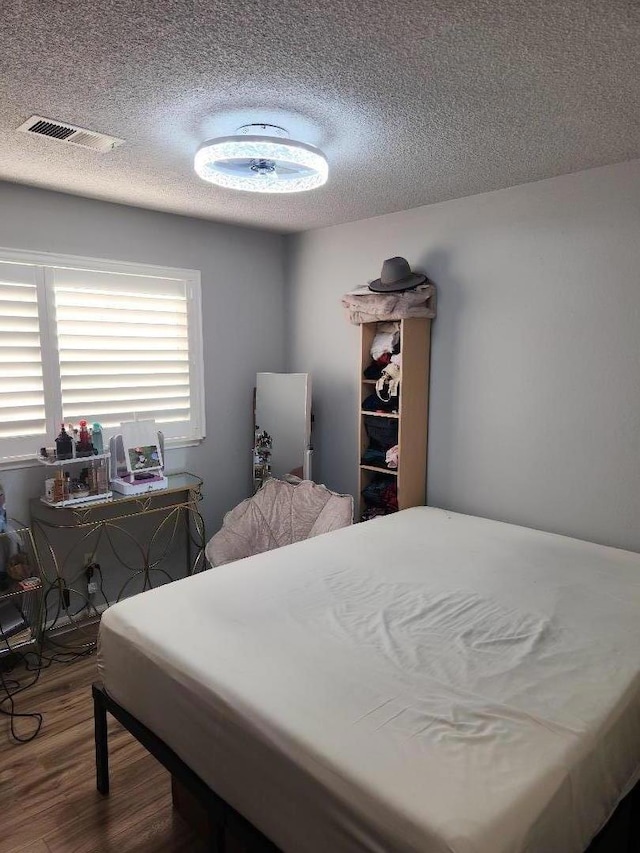 bedroom featuring hardwood / wood-style floors and a textured ceiling