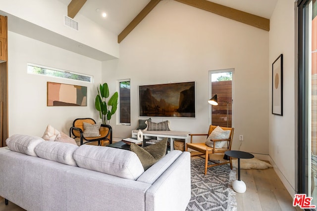 living room with light wood-type flooring, a wealth of natural light, beamed ceiling, and high vaulted ceiling