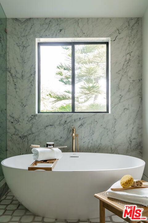 bathroom with a wealth of natural light and a tub to relax in