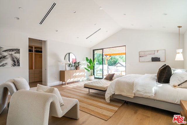 bedroom featuring access to exterior, vaulted ceiling, and light hardwood / wood-style floors