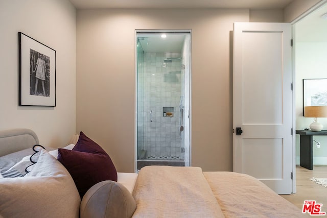 bedroom with light wood-type flooring and ensuite bathroom