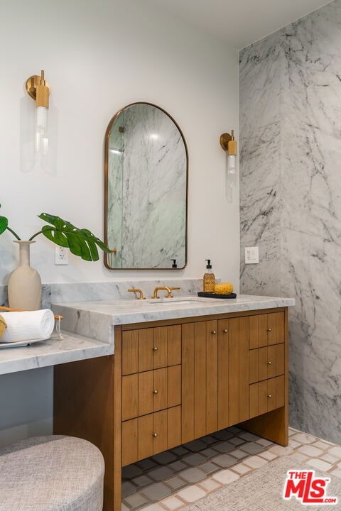 bathroom with vanity and tile walls