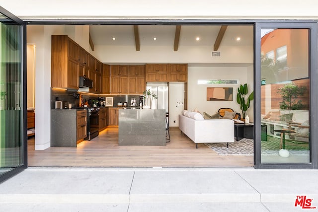 kitchen featuring black / electric stove and stainless steel fridge