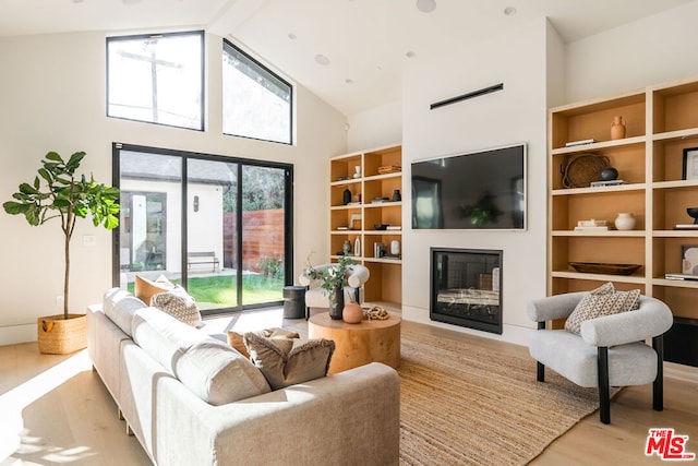 living room featuring high vaulted ceiling and light hardwood / wood-style flooring