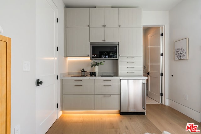 kitchen with light hardwood / wood-style floors, white cabinetry, and appliances with stainless steel finishes